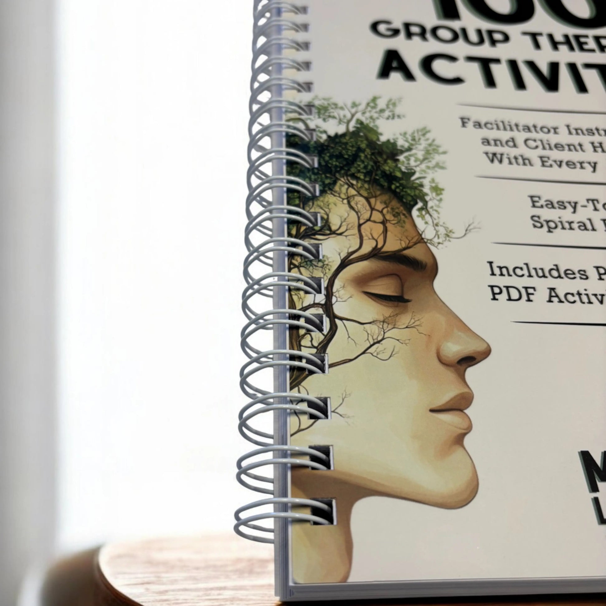 A detailed macro shot of the easy-to-scan, lay-flat spiral binding on the 100 Group Therapy Activities workbook.