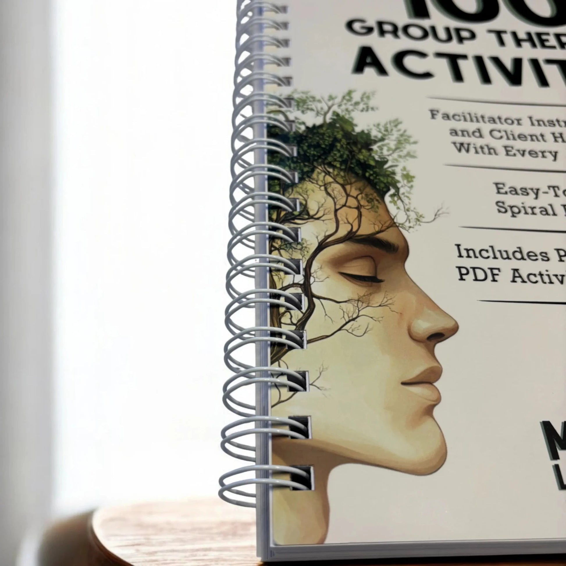 A detailed macro shot of the easy-to-scan, lay-flat spiral binding on the 100 Group Therapy Activities workbook.
